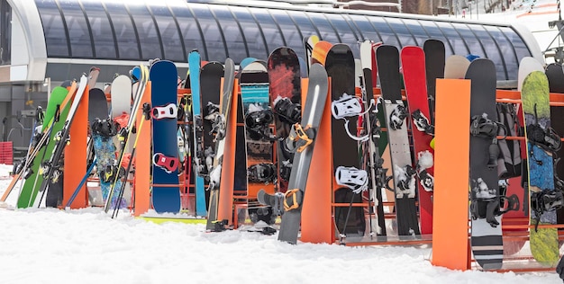 Foto alpine skier und snowboards, die sich am wintertag auf dem skiträger auf schnee lehnen