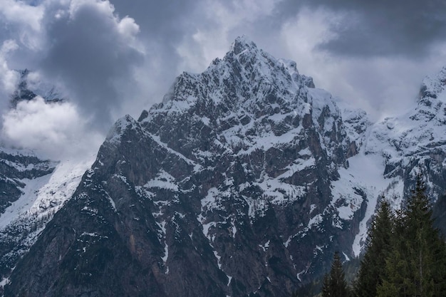 Alpiner Schneegipfel gegen einen düsteren Himmel Dolomiten Italien Frühling in den Bergen Das Konzept und die Idee der Variabilität des Wetters in den Bergen