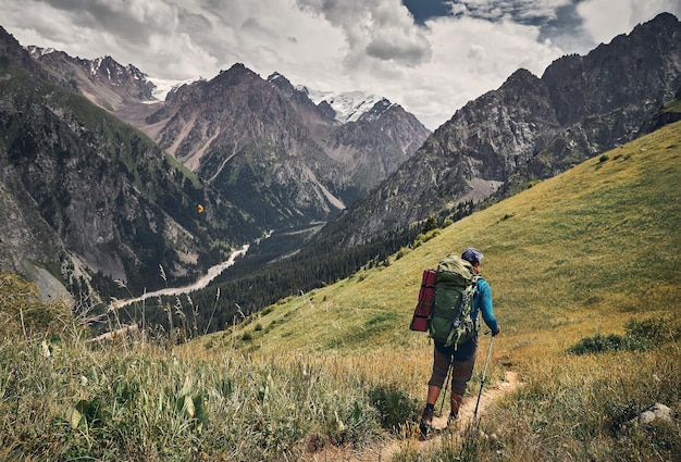Foto alpinista com mochila grande nas montanhas