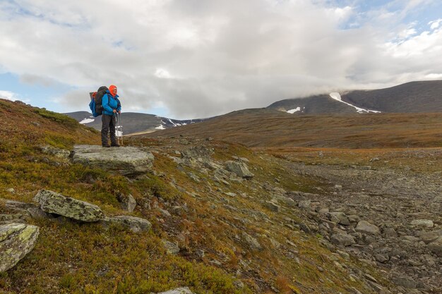 Alpinista com mochila na trilha Kungsleden admirando a natureza de Sarek