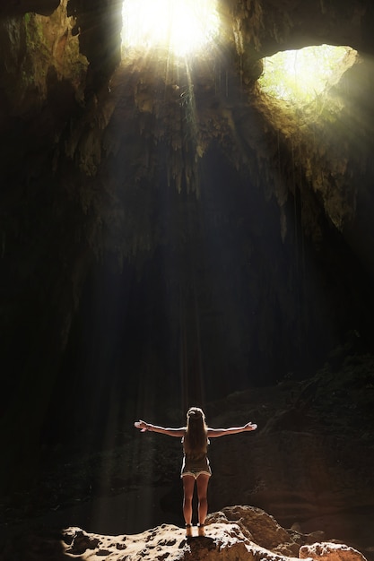 Foto alpinista de mulher em pé na caverna