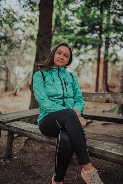 Alpinista de mulher sentada na floresta descansando durante caminhada na bela floresta.