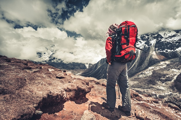 Alpinista de pé em uma montanha apreciando a vista