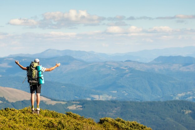 Alpinista de pé no topo da montanha. Unidade com o conceito de natureza.