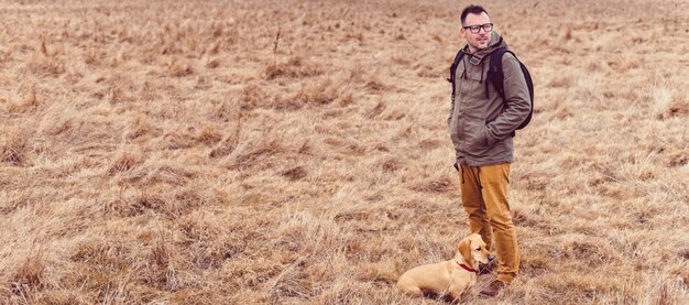 Alpinista e cachorro descansando nas pastagens