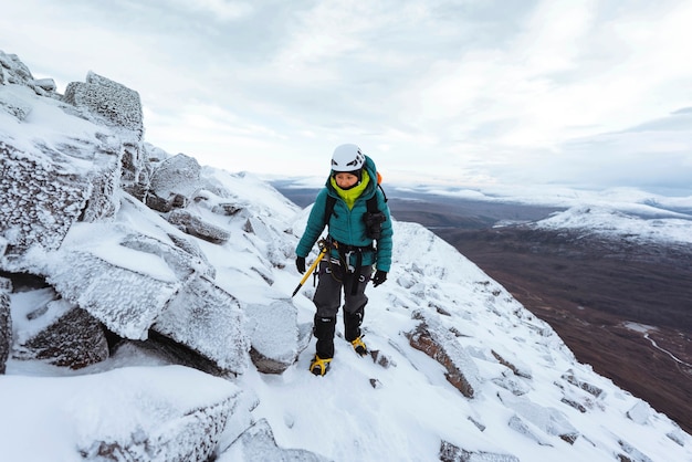Alpinista escalada en la nieve en Liathach Ridge, Escocia