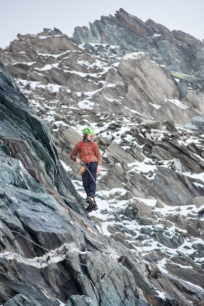 Alpinista escalando a montanha rochosa na Áustria