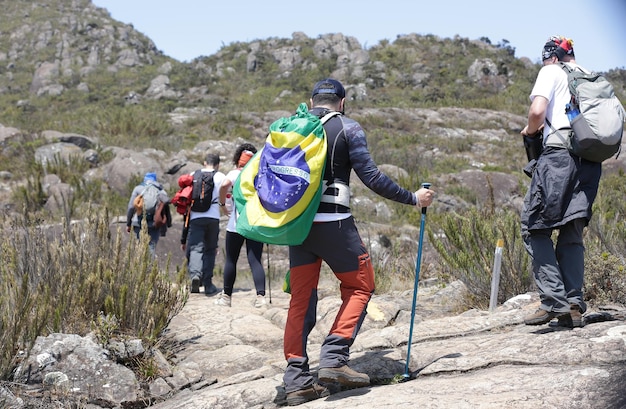 Alpinista escalando os picos mais altos do brasil nas montanhas com extensa caminhada e mochila.