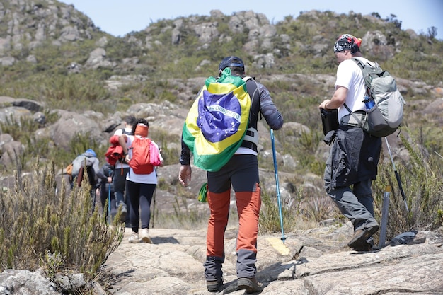 Alpinista escalando os picos mais altos do brasil nas montanhas com extensa caminhada e mochila.