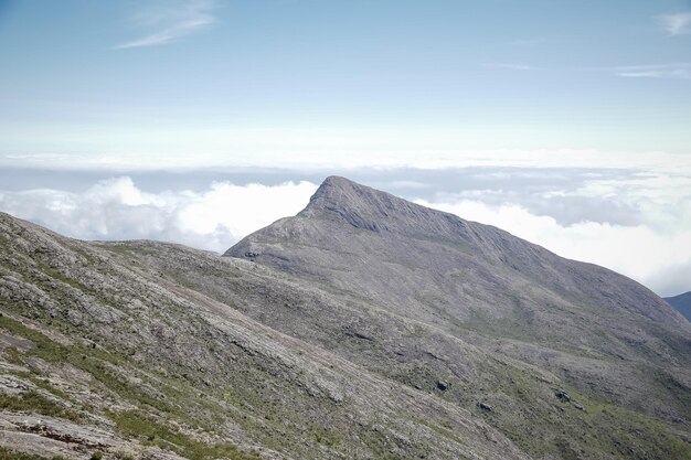 Alpinista escalando os picos mais altos do brasil nas montanhas com extensa caminhada e mochila.