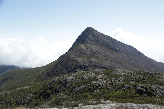 Alpinista escalando os picos mais altos do brasil nas montanhas com extensa caminhada e mochila.