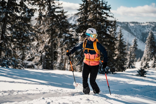 Alpinista esquí de travesía caminar esquí mujer alpinista en las montañas Esquí de travesía en paisaje alpino con árboles nevados Aventura deporte de invierno Esquí freeride