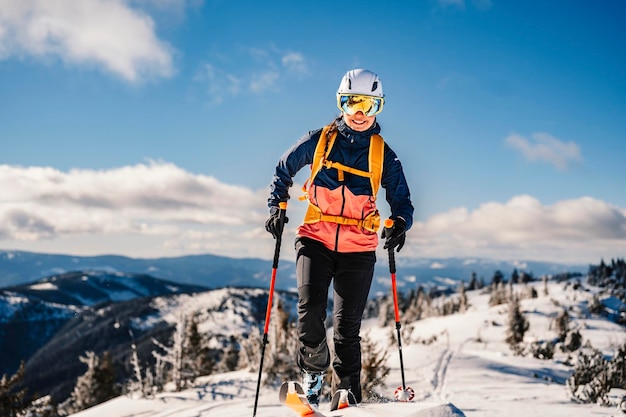 Alpinista esquí de travesía caminar esquí mujer alpinista en las montañas Esquí de travesía en paisaje alpino con árboles nevados Aventura deporte de invierno Esquí freeride