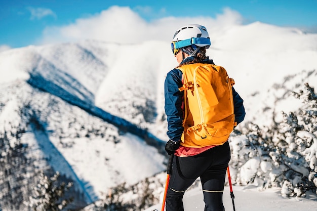 Alpinista esquí de travesía caminar esquí mujer alpinista en las montañas Esquí de travesía en paisaje alpino con árboles nevados Aventura deporte de invierno Esquí freeride