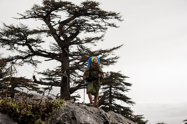 Alpinista feminina em pé de capa de chuva em uma montanha