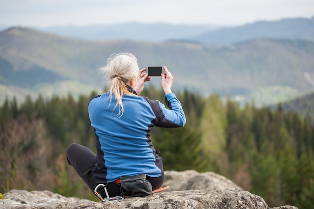 Alpinista feminina no topo da rocha