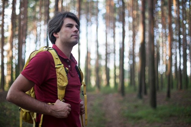 Alpinista - homem caminhadas na floresta. Alpinista masculina, olhando para o lado andando na floresta. Modelo masculino caucasiano ao ar livre na natureza.