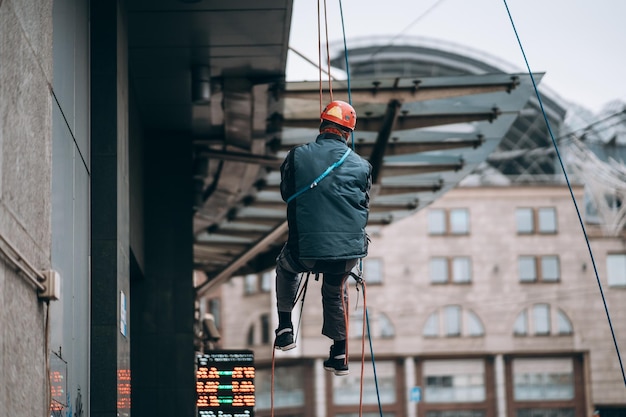 Foto alpinista industrial em uniforme e capacete sobe