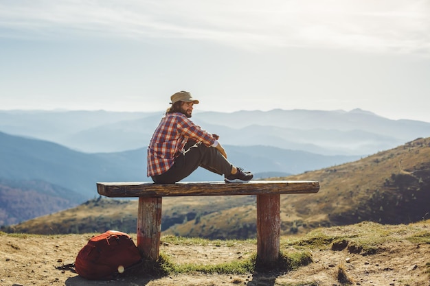 Alpinista masculina descansando no topo da montanha