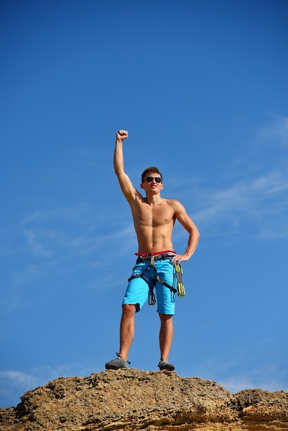 Alpinista masculino levantando a mão