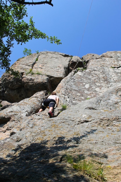 Foto alpinista mulher sobe em uma rocha