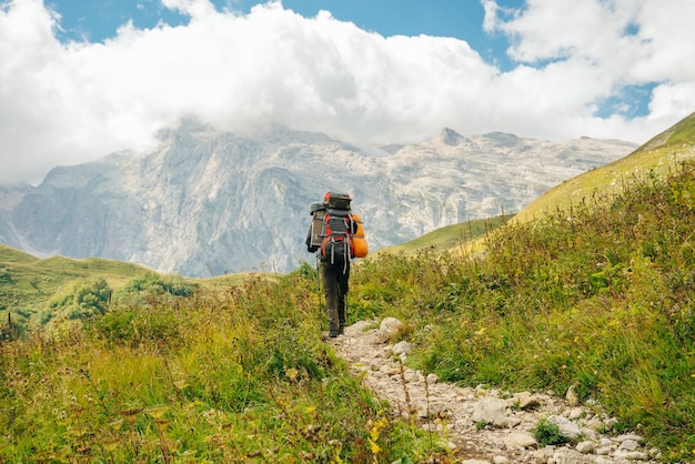 Alpinista nas montanhas da república da adygea com grandes mochilas rússia