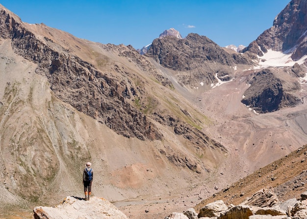 Alpinista no fundo da montanha rochosa Fann Mountains Tajiquistão Ásia Central