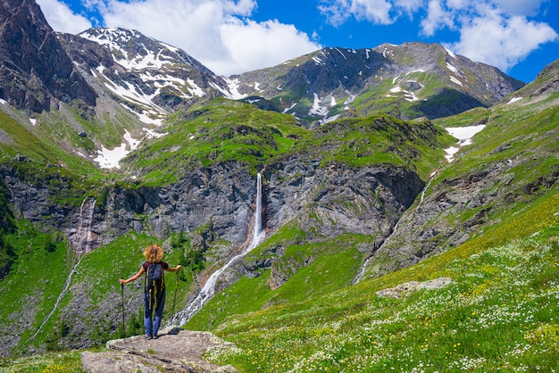 Alpinista olhando cachoeira na montanha