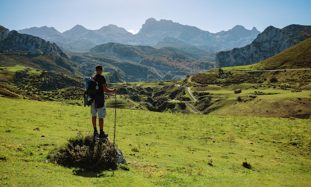 Alpinista olhando paisagem com caminho entre montanhas