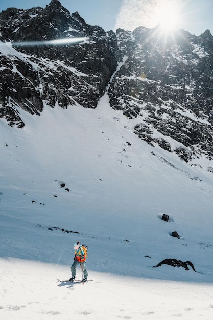 Alpinista sertão esqui andando alpinista nas montanhas Esqui de turismo na paisagem alpina com árvores nevadas Esporte de inverno de aventura