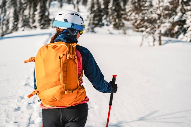 Alpinista sertão esqui andando esqui mulher alpinista nas montanhas Esqui de turismo na paisagem alpina com árvores nevadas Aventura esporte de inverno Esqui freeride