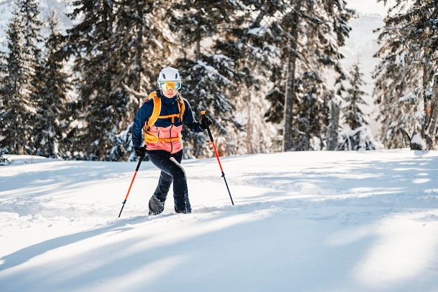 Alpinista sertão esqui andando esqui mulher alpinista nas montanhas Esqui de turismo na paisagem alpina com árvores nevadas Aventura esporte de inverno Esqui freeride