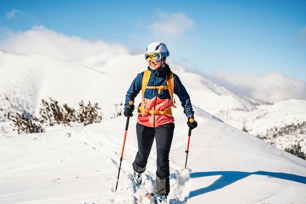 Alpinista sertão esqui andando esqui mulher alpinista nas montanhas Esqui de turismo na paisagem alpina com árvores nevadas Aventura esporte de inverno Esqui freeride