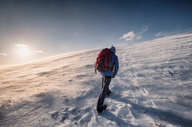 Alpinista subindo ao pico no inverno