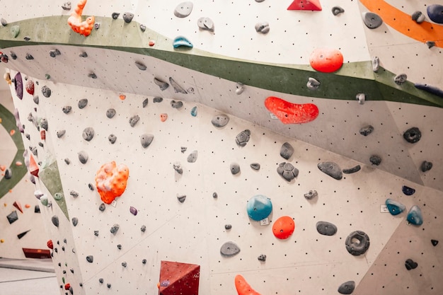 Alpinista vestindo equipamento de escalada Praticando escalada em uma parede de rocha dentro de casa Esportes radicais e conceito de boulder