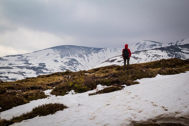 Alpinista viajando pela foto de paisagem de encostas de montanhas nevadas