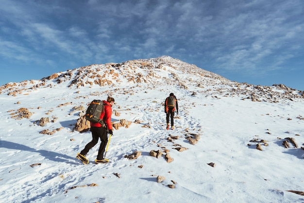 Alpinistas escalando a montanha de neve