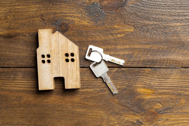 Alquiler de apartamento de casa y llave en una superficie de madera con vista superior