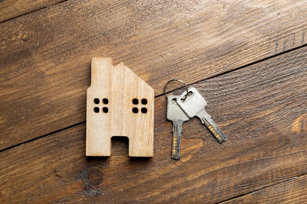 Alquiler de apartamento de casa y llave en una superficie de madera con vista superior