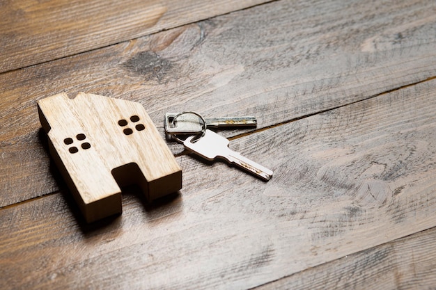 Alquiler de apartamento de casa y llave en una superficie de madera con vista superior