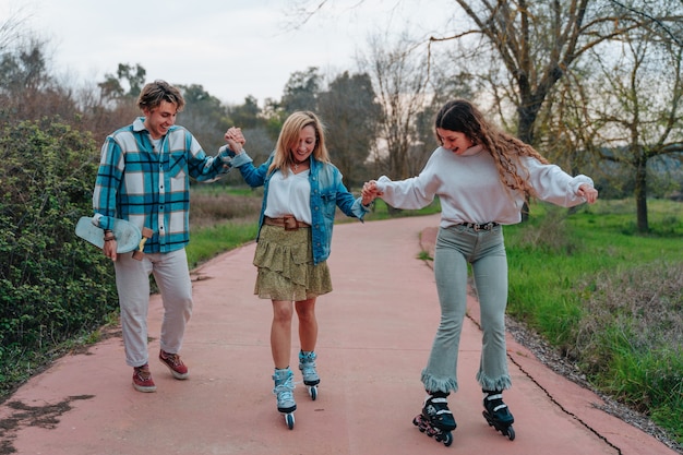 Als Familie Sport treiben. Der Sohn auf einem Skate, die Schwester auf einem Rollschuh und die Mutter auf einem Fahrrad.