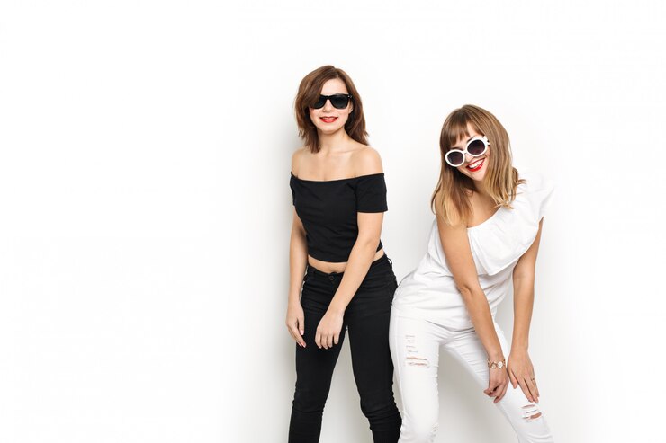 Alta moda. Modelo de glamour elegante jovens mulheres com lábios vermelhos em um preto e branco hipster brilhante roupas e óculos de sol.