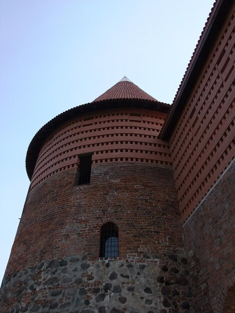 Foto una alta torre de ladrillo con una ventana que dice el número 10 en ella