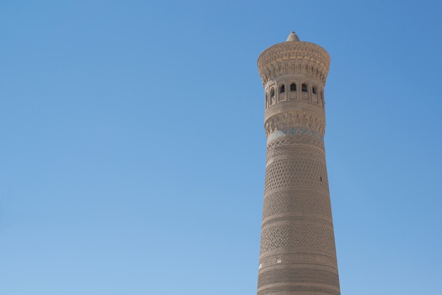 Alta torre ovalada de ladrillos, antiguos edificios asiáticos. los detalles de la arquitectura del Asia Central medieval