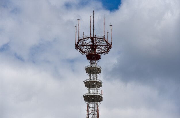 Foto alta torre de transmisión de radio tv con antenas en el fondo de las nubes.