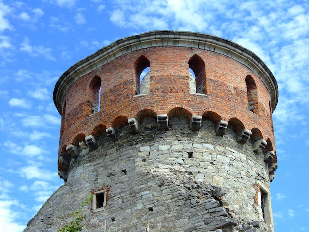 Alta torre de vigilancia redonda de una fortaleza o castillo medieval sobre un fondo de cielo azul