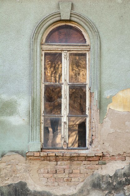 Foto alta ventana de madera en la pared en ruinas de la casa