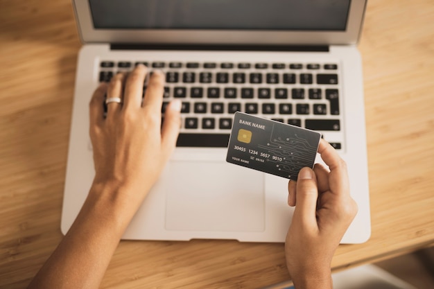 Foto alta vista de laptop y tarjeta de crédito para compras