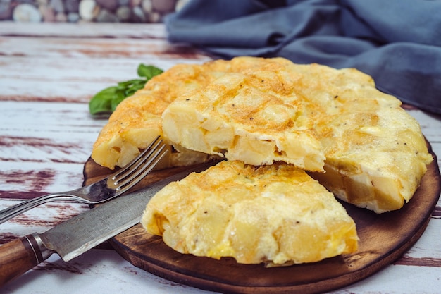 Alta vista de un plato con tortilla de patata española cortada en octavos sobre una mesa de madera