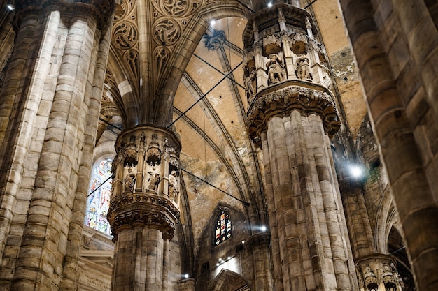Altas columnas talladas bajo el techo abovedado en el duomo italia milán